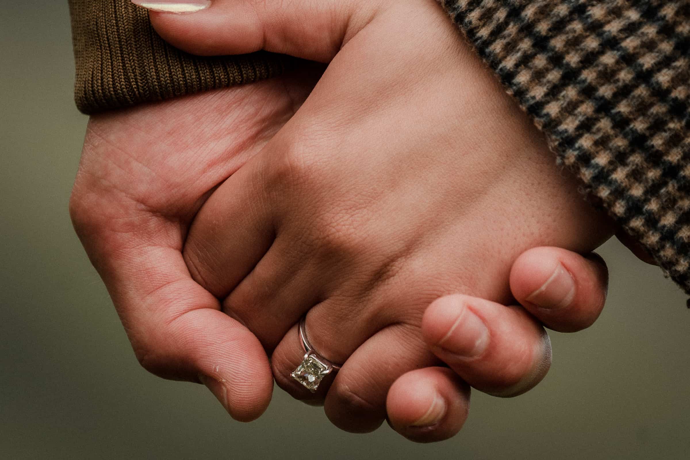 Newly engaged couple holding hands